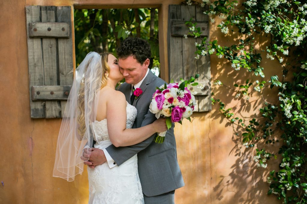Royal Palms wedding photographer couple embracing on their wedding day in front of a wooden window frame